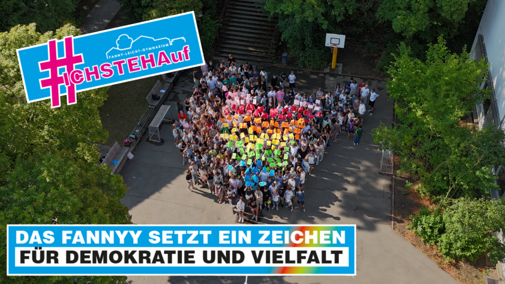 Schülerinnen und Schüler des Fanny-Leicht-Gymnasiums bilden im Vorderhof ein Regenbogenherz mit verschiedenen Blättern.